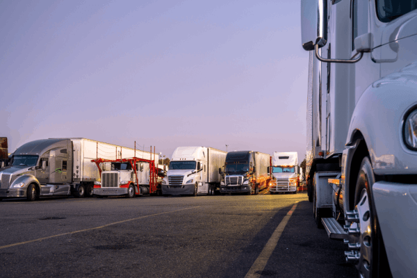 Commercial trucks parked at rest stop illustrating trucking company liability for driver accidents and fleet management responsibilities
