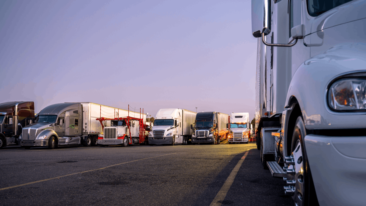 Commercial trucks parked at rest stop illustrating trucking company liability for driver accidents and fleet management responsibilities