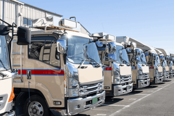 What does trucking liability insurance cover after an accident - commercial fleet vehicles with utility equipment at warehouse