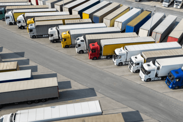 Commercial trucks parked at freight depot illustrating what is not covered by trucking liability insurance policies