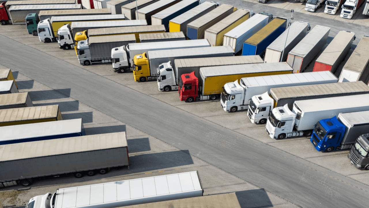 Commercial trucks parked at freight depot illustrating what is not covered by trucking liability insurance policies