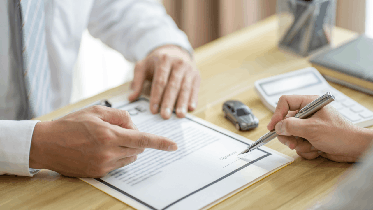 Negotiating with insurance adjuster after a truck accident — victim signing documents at desk