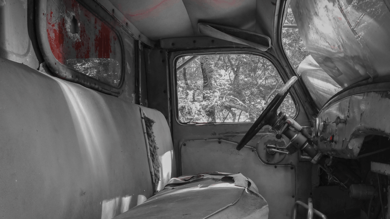 Damaged truck interior showing truck accident evidence with crushed cabin and red stains