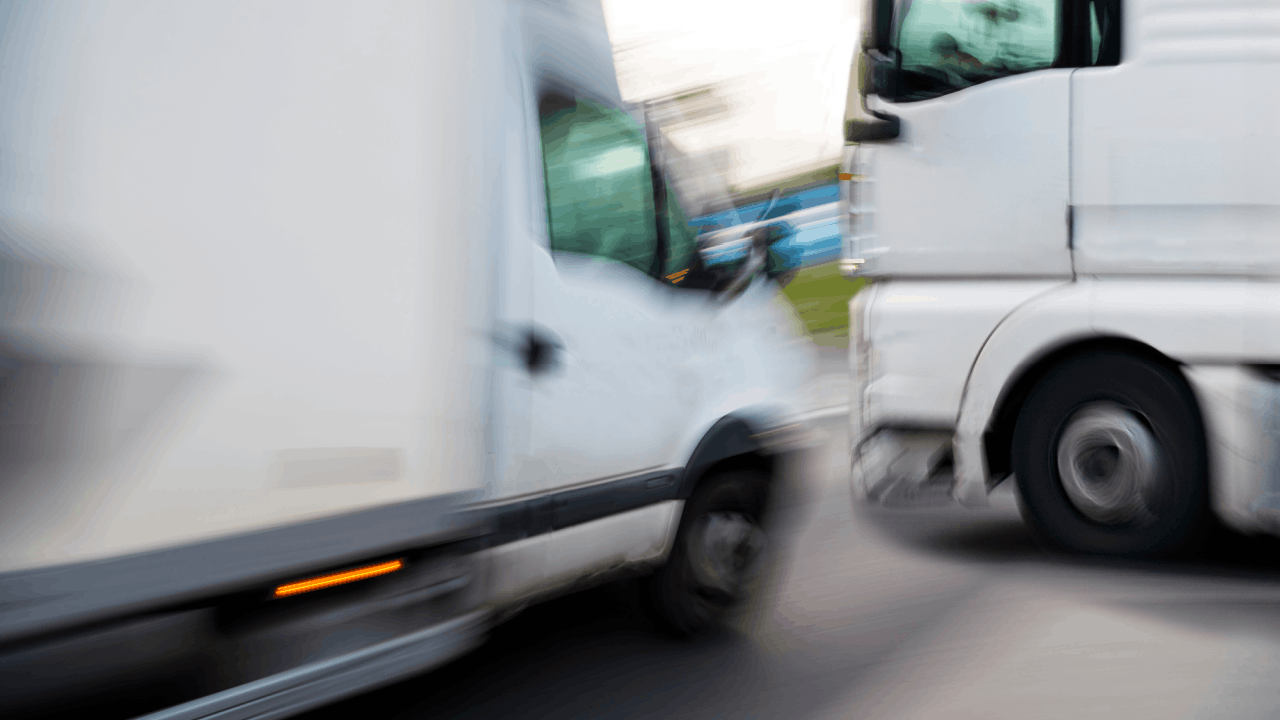 Semi truck rear-ending a smaller white vehicle on the road