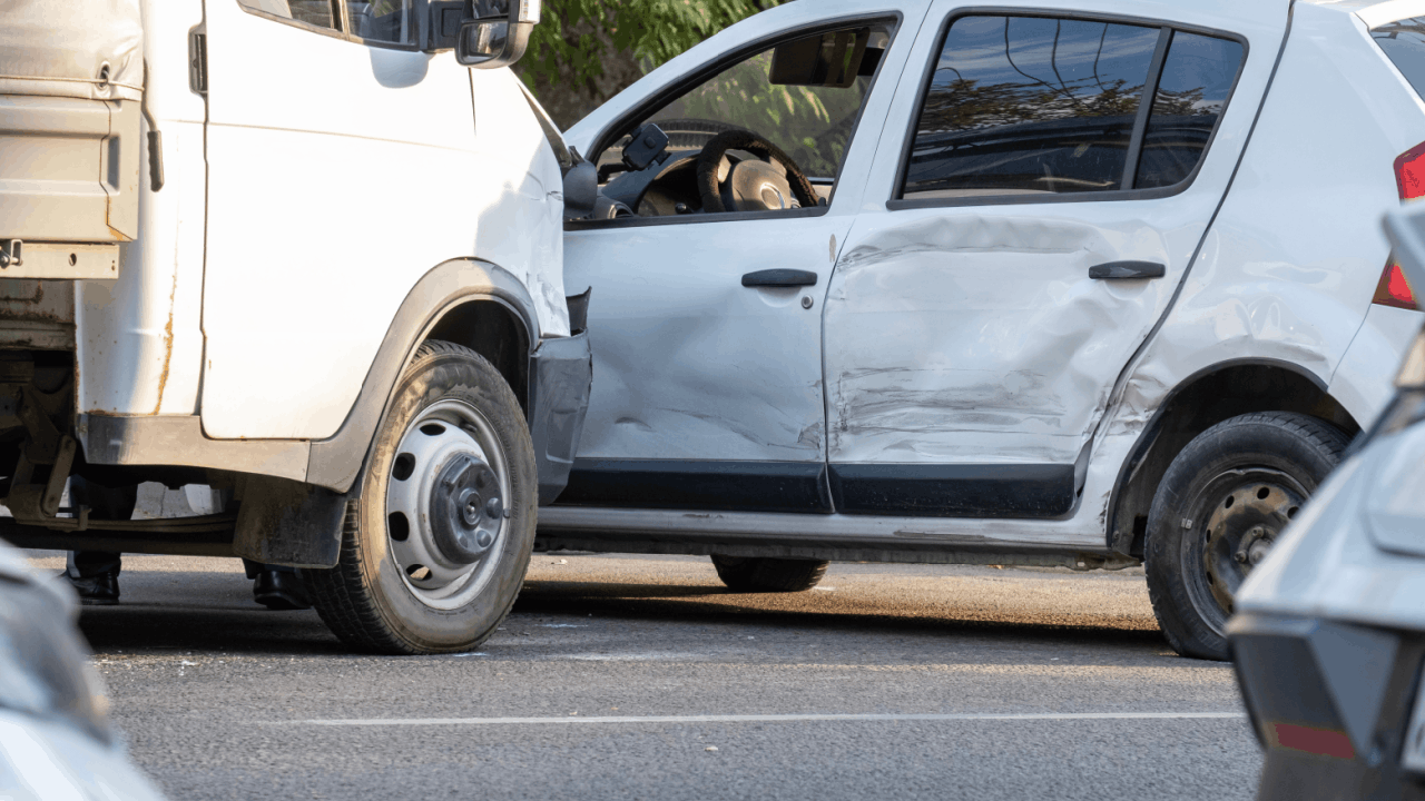 truck accident white car with severe side damage on road