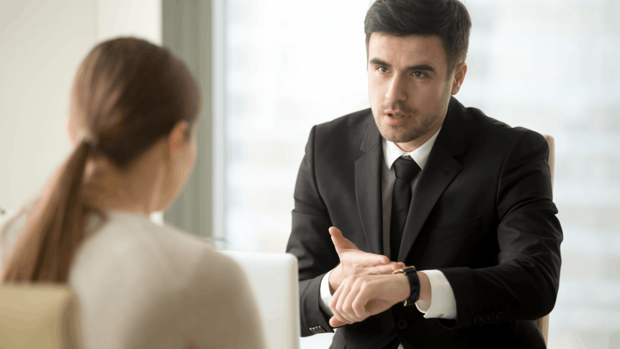 Truck accident claim deadlines explained by an attorney pointing to his watch during a client consultation.