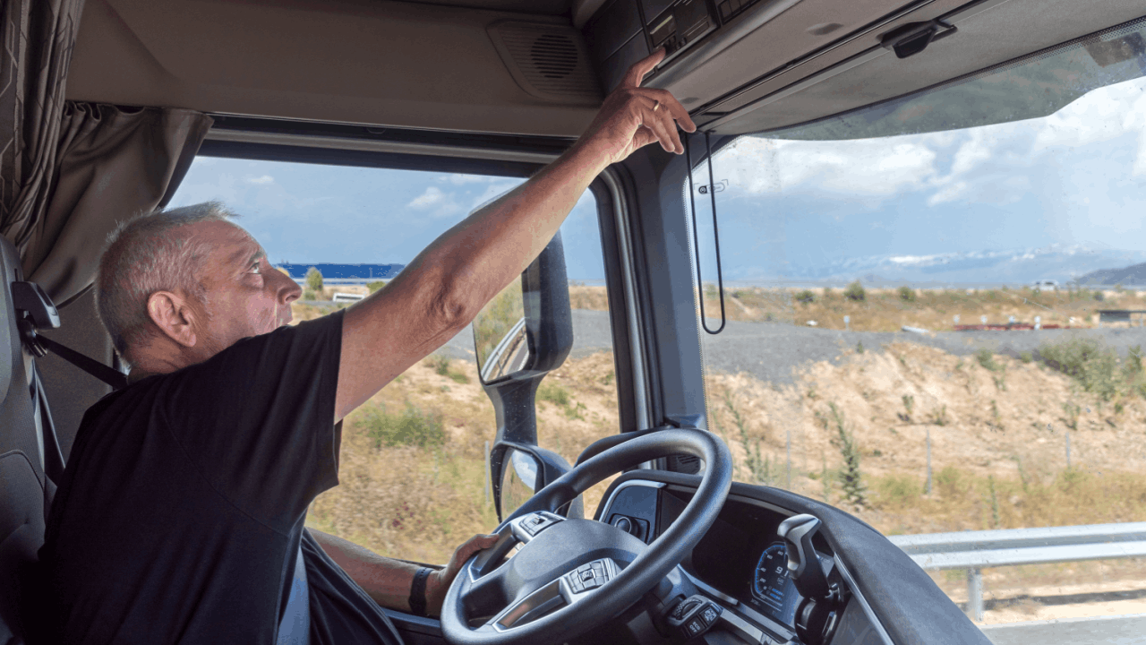 Truck driver inside cab showing hours violation risk