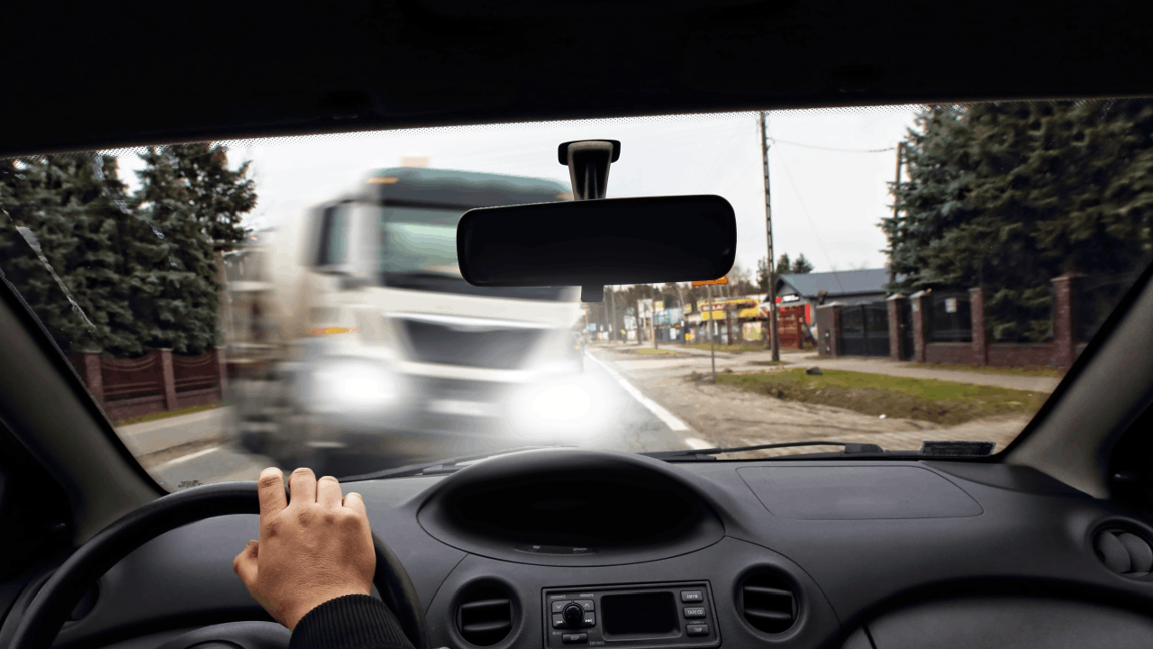 Filing a claim after a crash with an out-of-service driver shown from inside a car facing an oncoming truck
