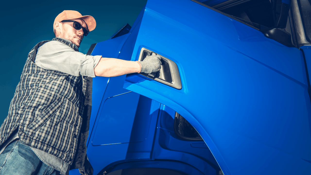 Truck driver in cap and gloves opening blue semi-truck cab door