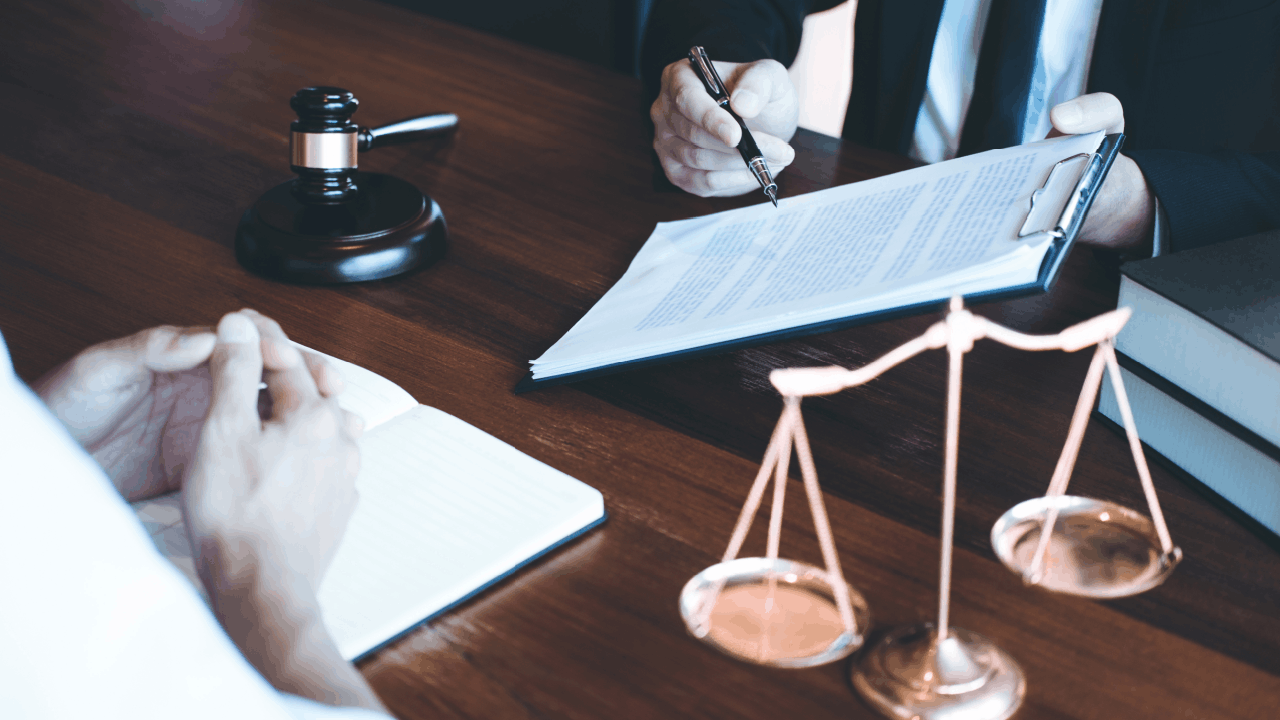 non-domiciled CDL accident claim being reviewed by an attorney and client at a desk with a gavel and scales of justice